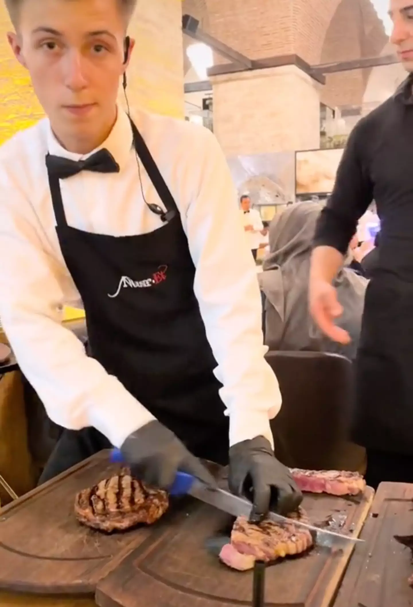 A waiter accidentally knocked the steak off the table when slicing another to vigorously.