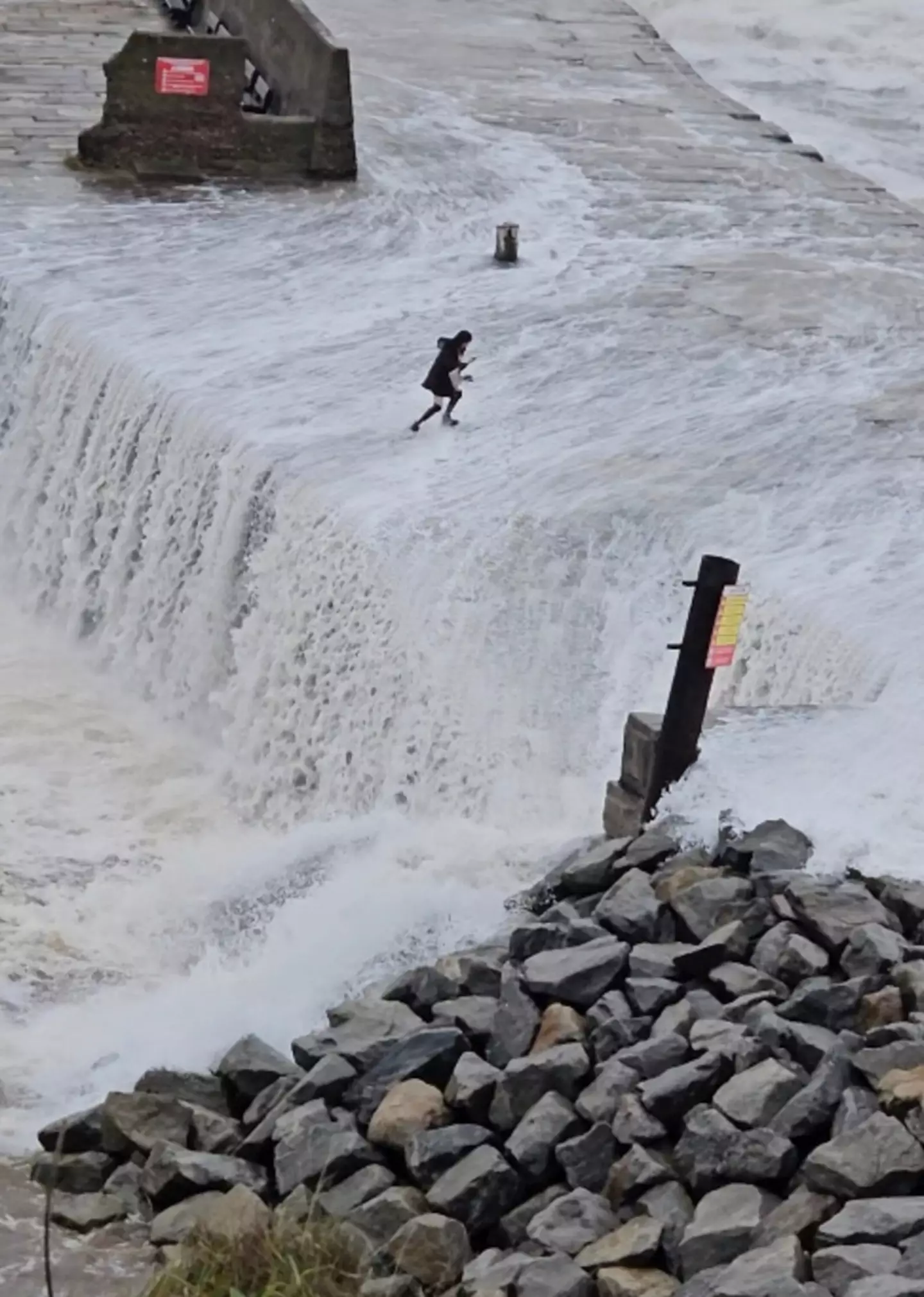 A tourist was caught in the middle of Storm Ciaran after she was swept off her feet by a huge wave while trying to take a selfie on a pier.