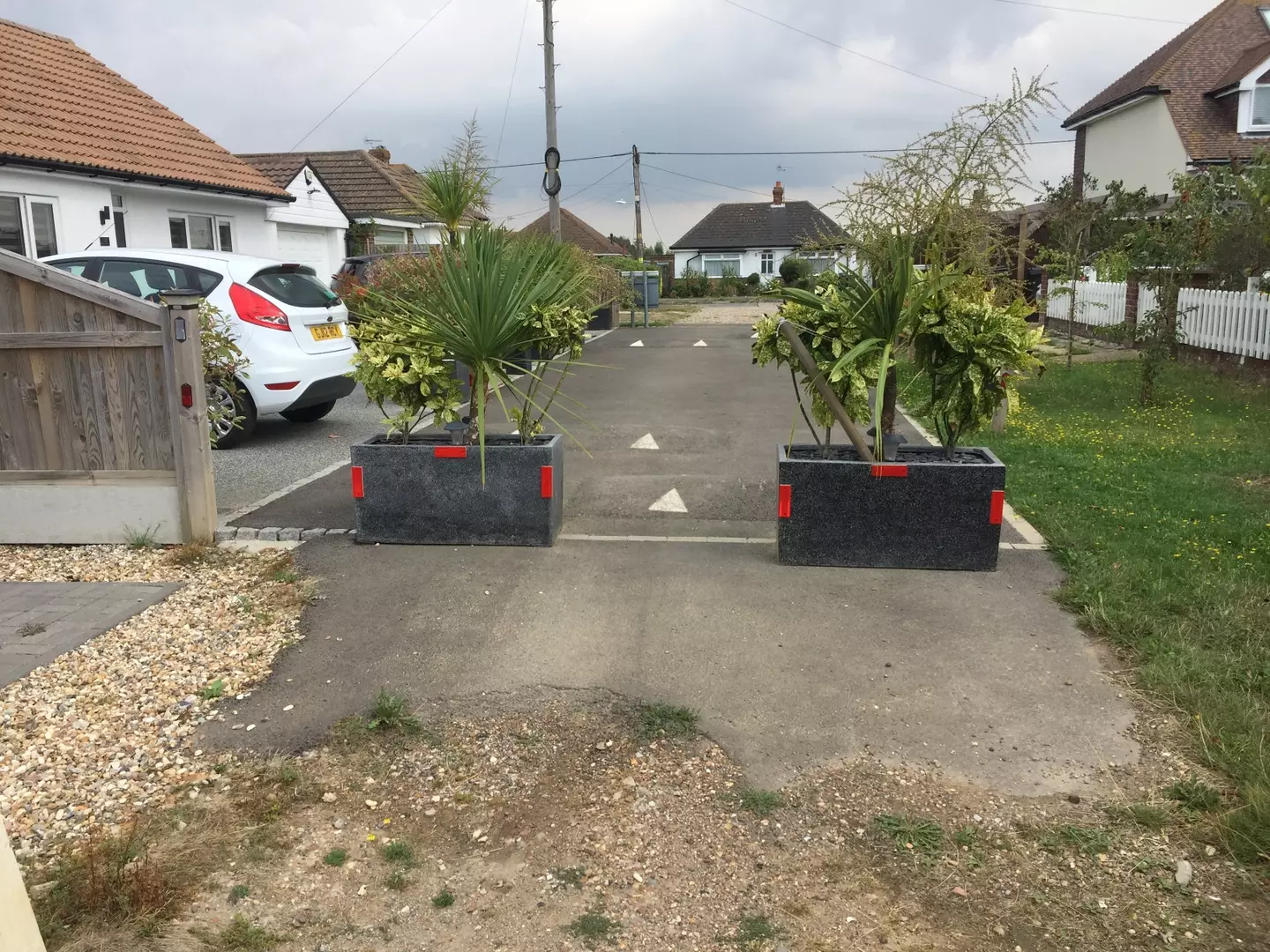 While the speed bumps didn't end up doing the trick, sticking a couple of big planters directly in the road worked.