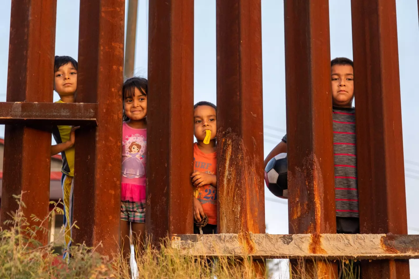 Children playing at the Mexico-US border wall, built by the Trump administration.