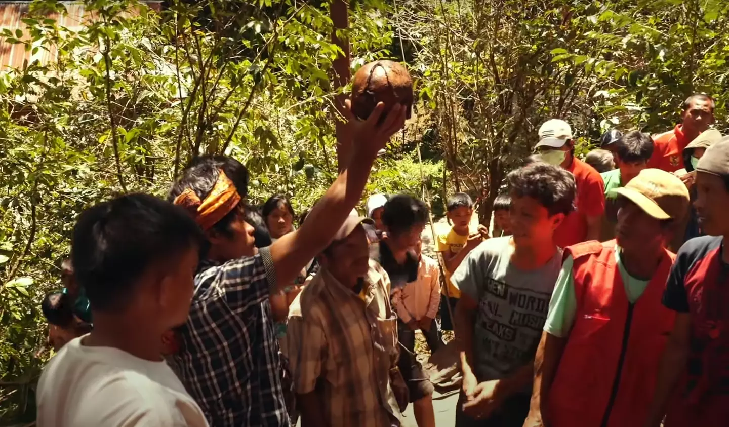 A Torajan man holds up the skull of his relative as part of the 'walking dead' ritual.