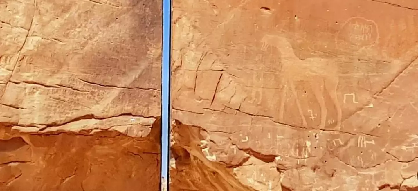 Petroglyphs are next to the crack in the rock.
