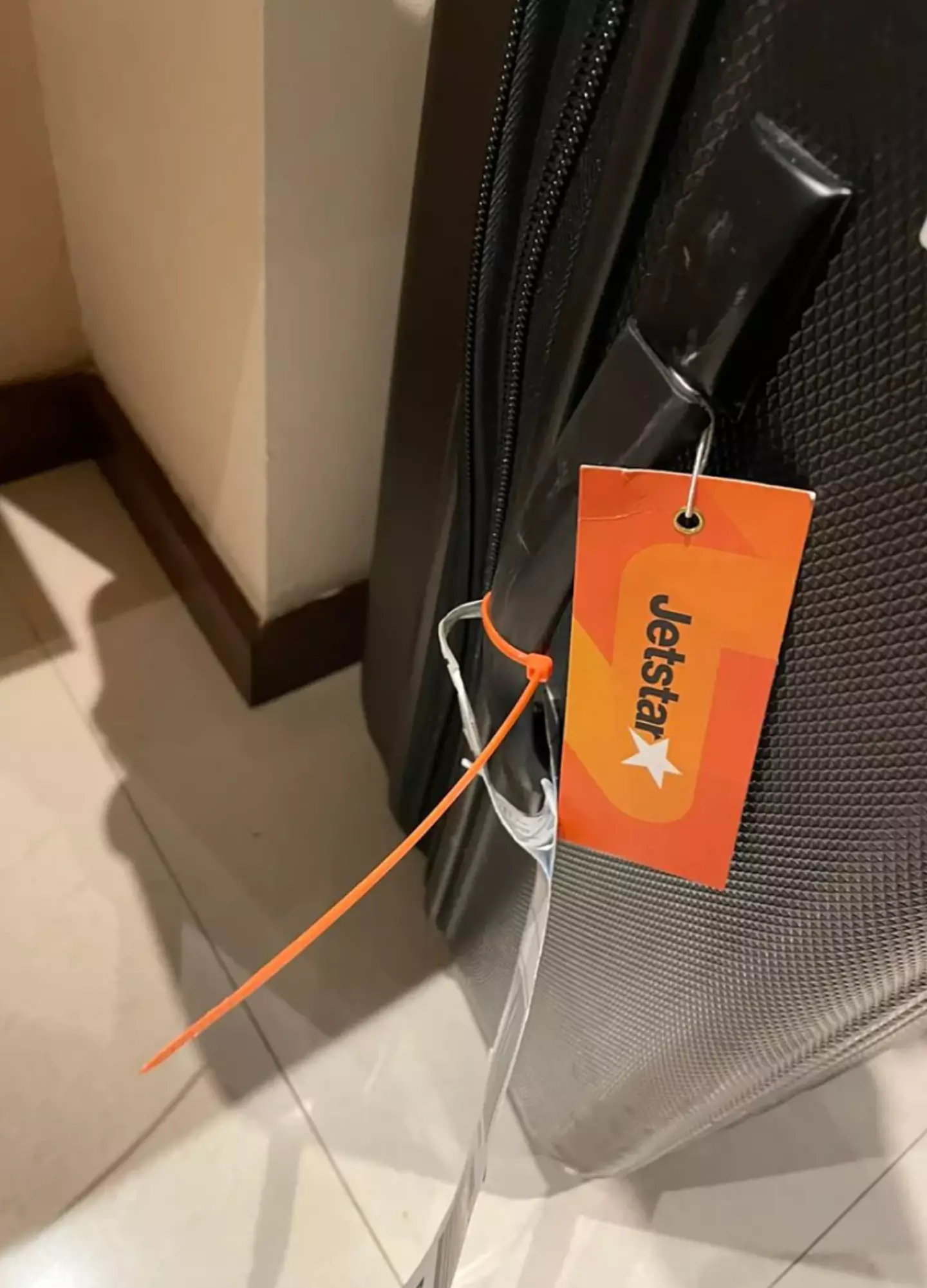 A woman was left puzzled when her suitcase arrived with an orange cable tie attached.