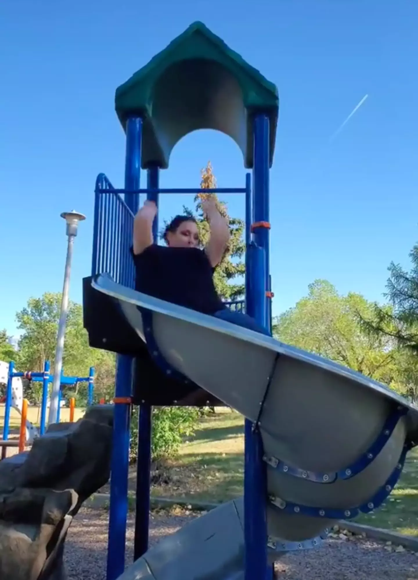 The woman started at the top of the slide lying on her bottom.