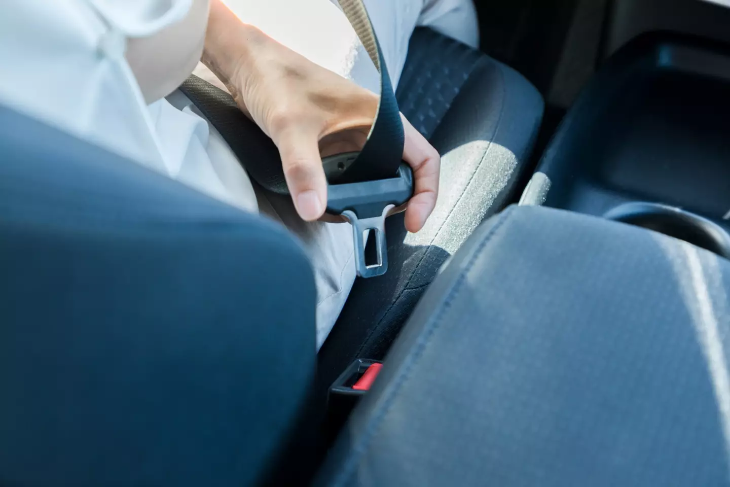 The button assists with ease in grabbing the belt at the right place to plug it in.