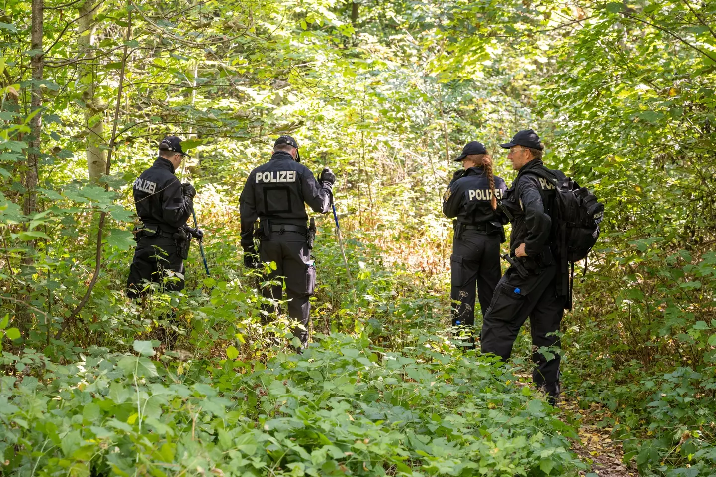 Police officers search for clues after a female body was discovered in a passenger car on 17 August 2022.