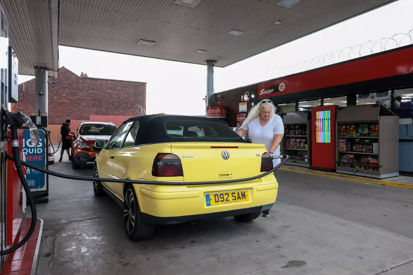 A woman filling up at the Limes Service Station.