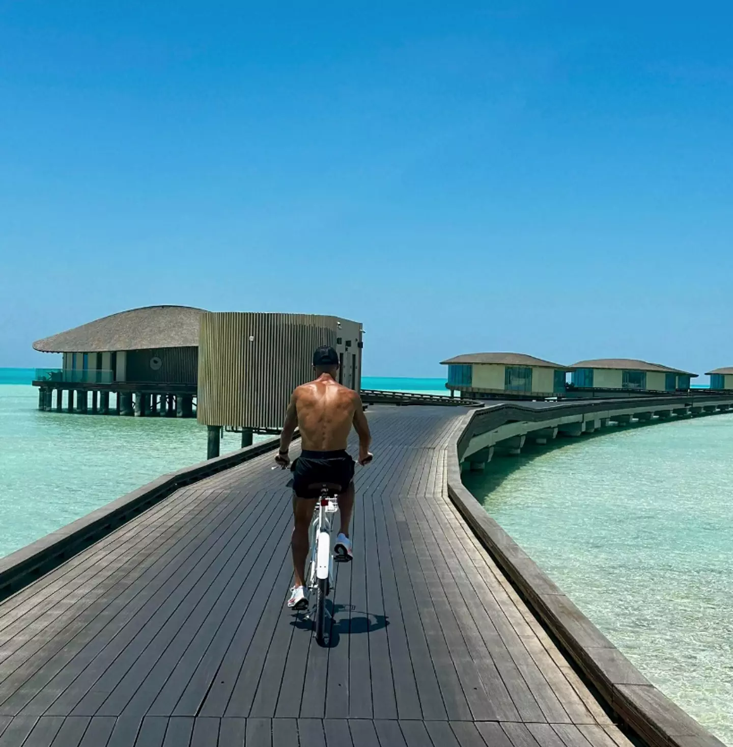 Ronaldo having a bike ride down the walkway to the overwater villas (Instagram / @cristiano)