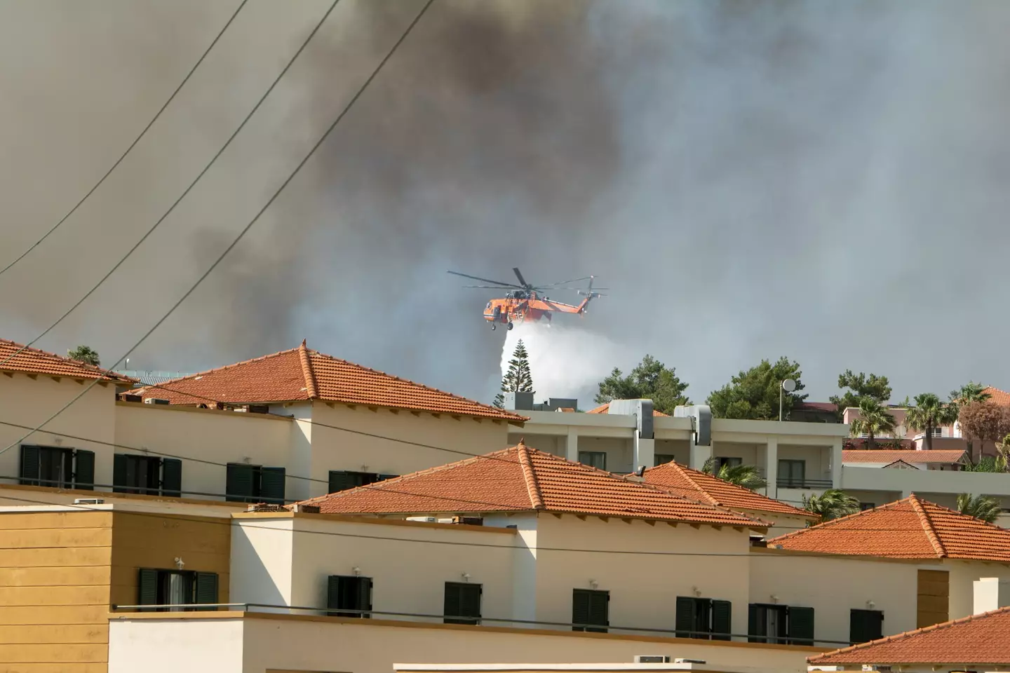 Helicopters help tackle the blazes in Rhodes.