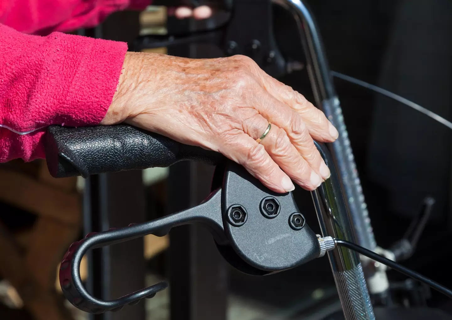 Elderly lady supported by a walking frame.