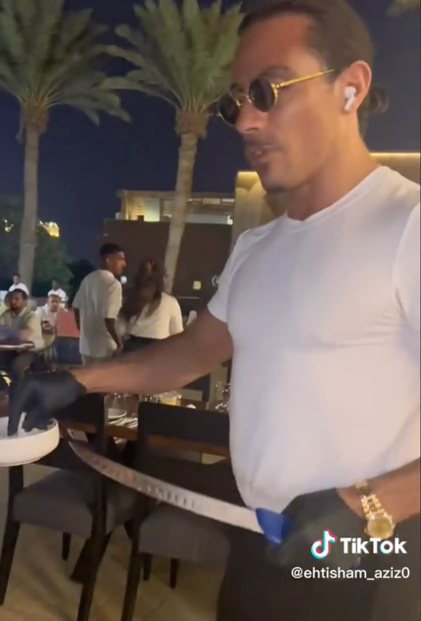 Salt Bae was allegedly talking on his AirPods while serving the table.