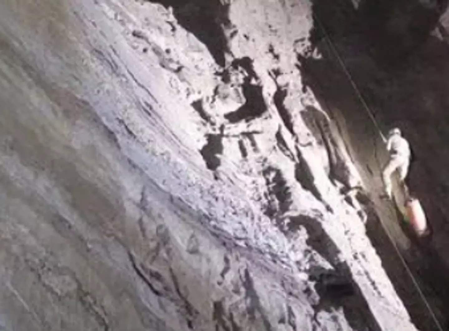 Caver Marcos Vilariño González makes his way past the flooded passage 1400m down.