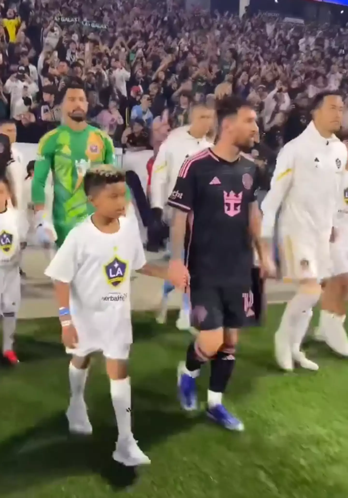Saint could be seen walking onto the pitch with Lionel Messi, one of the world's greatest footballers.