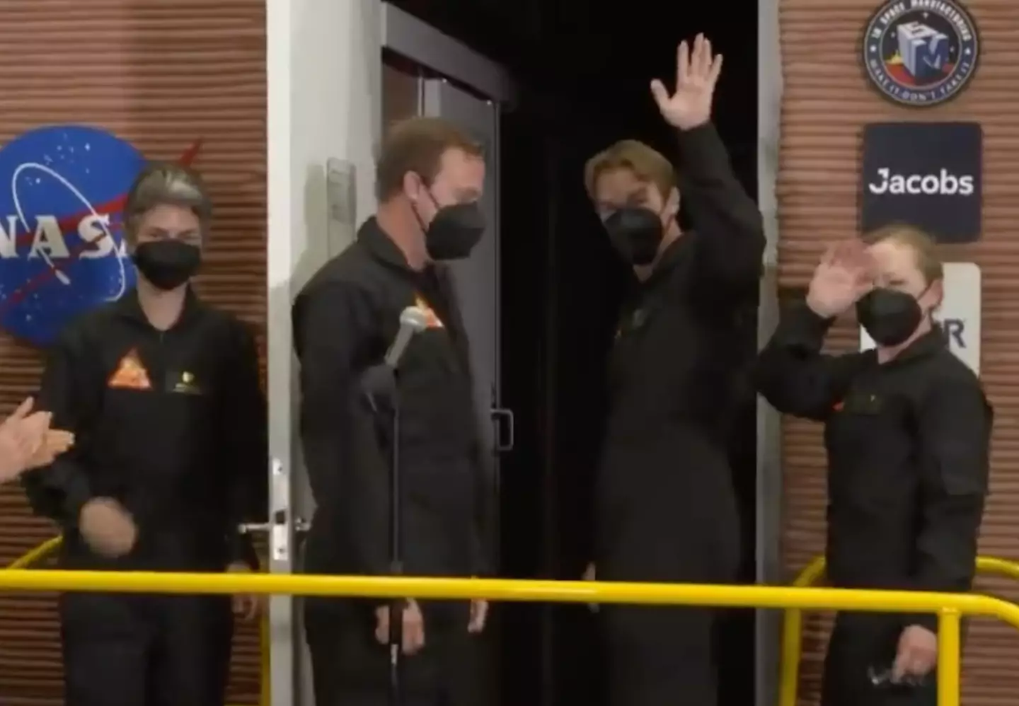 The crew waved goodbye as they made their way into the chamber.