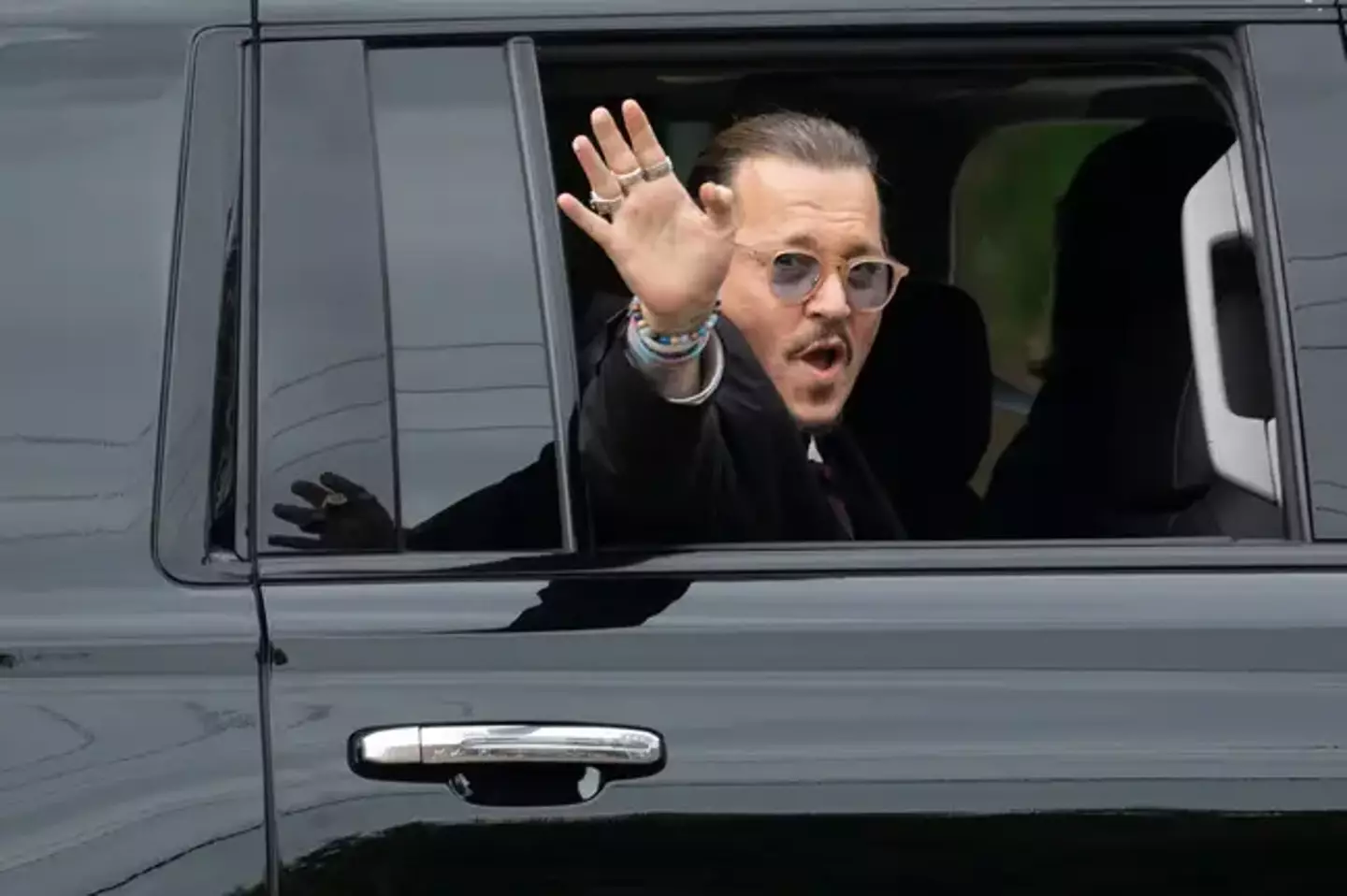 Johnny Depp waving to fans outside of the courthouse.
