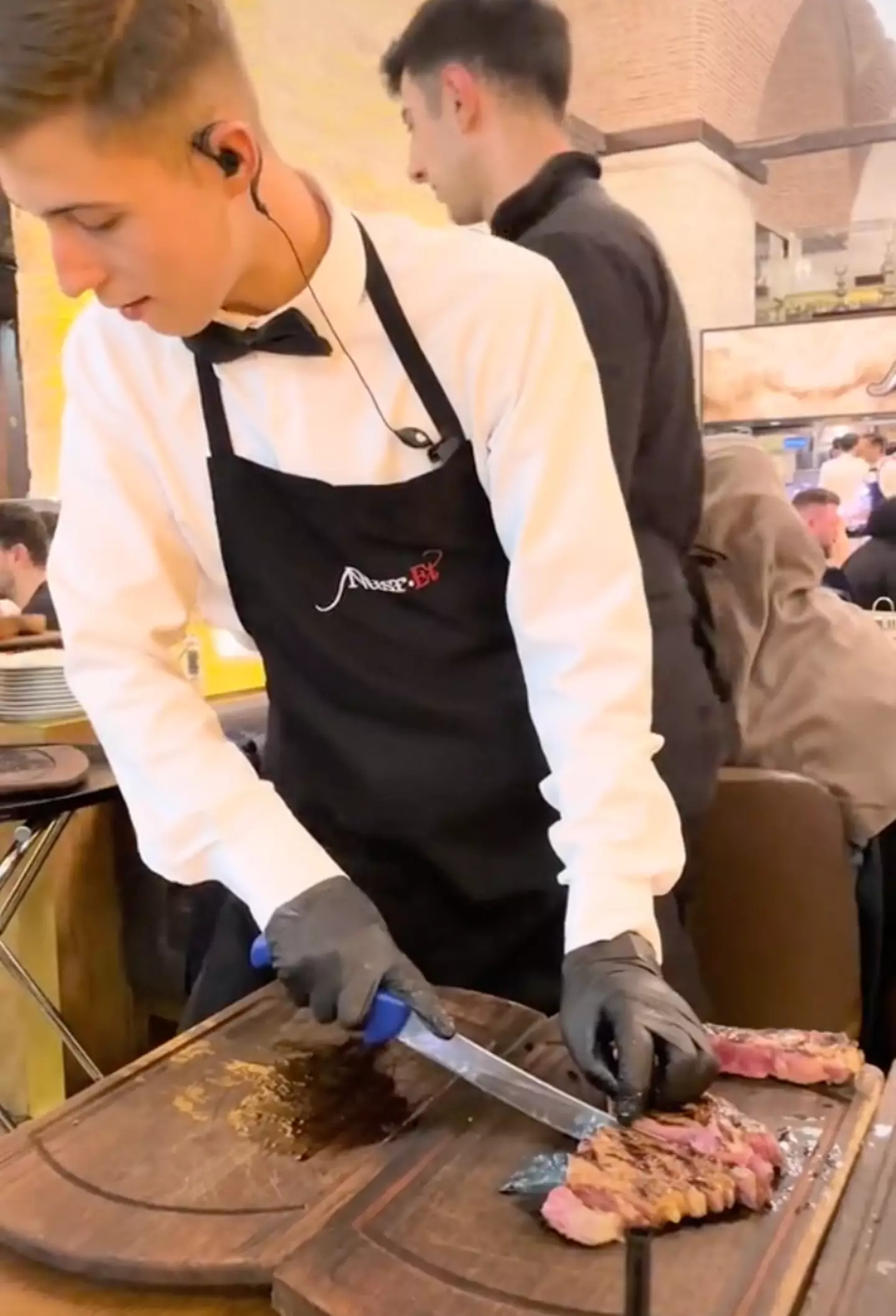 The waiter barely gave the dropped steak a glance before carrying on with his task.