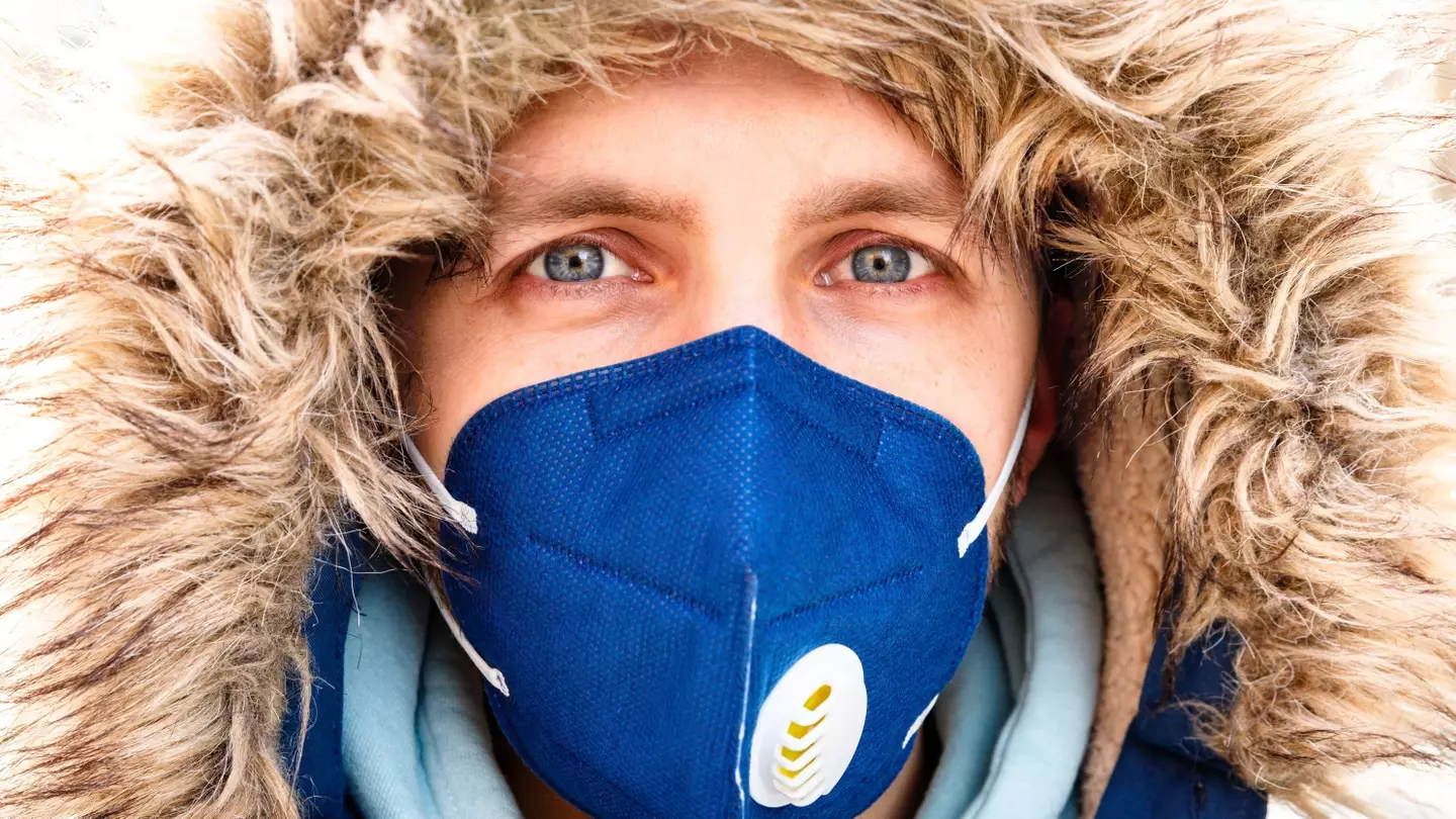 Closeup of man in hood wearing respirator N95 mask.