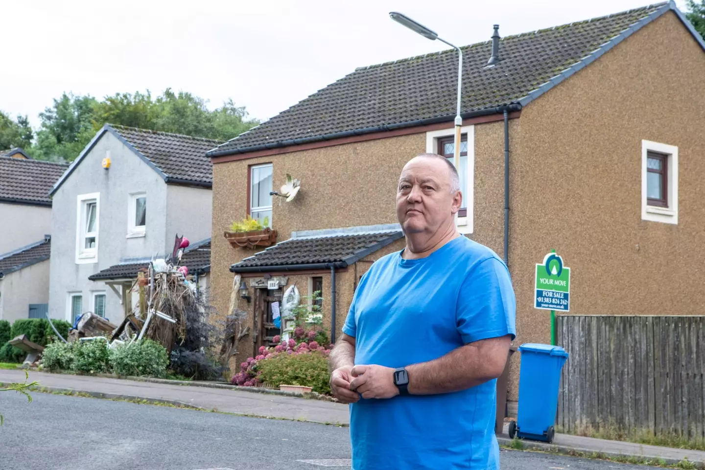 He says he can't sell the home because of the mess next door (SWNS)