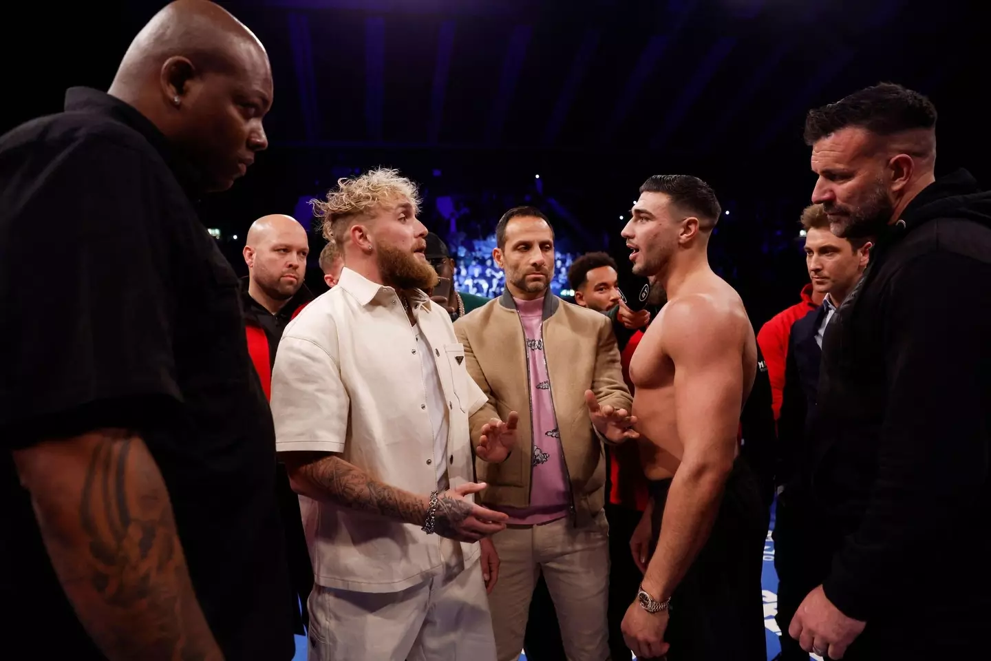 Jake Paul and Tommy Fury are facing off in the ring.
