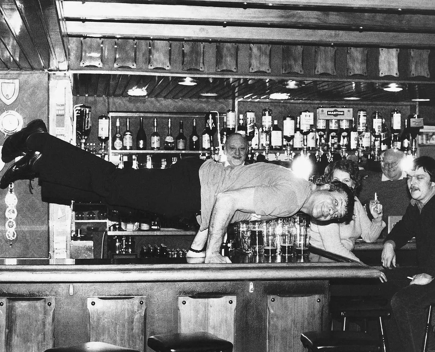 Oliver Reed performing a party trick on the bar.
