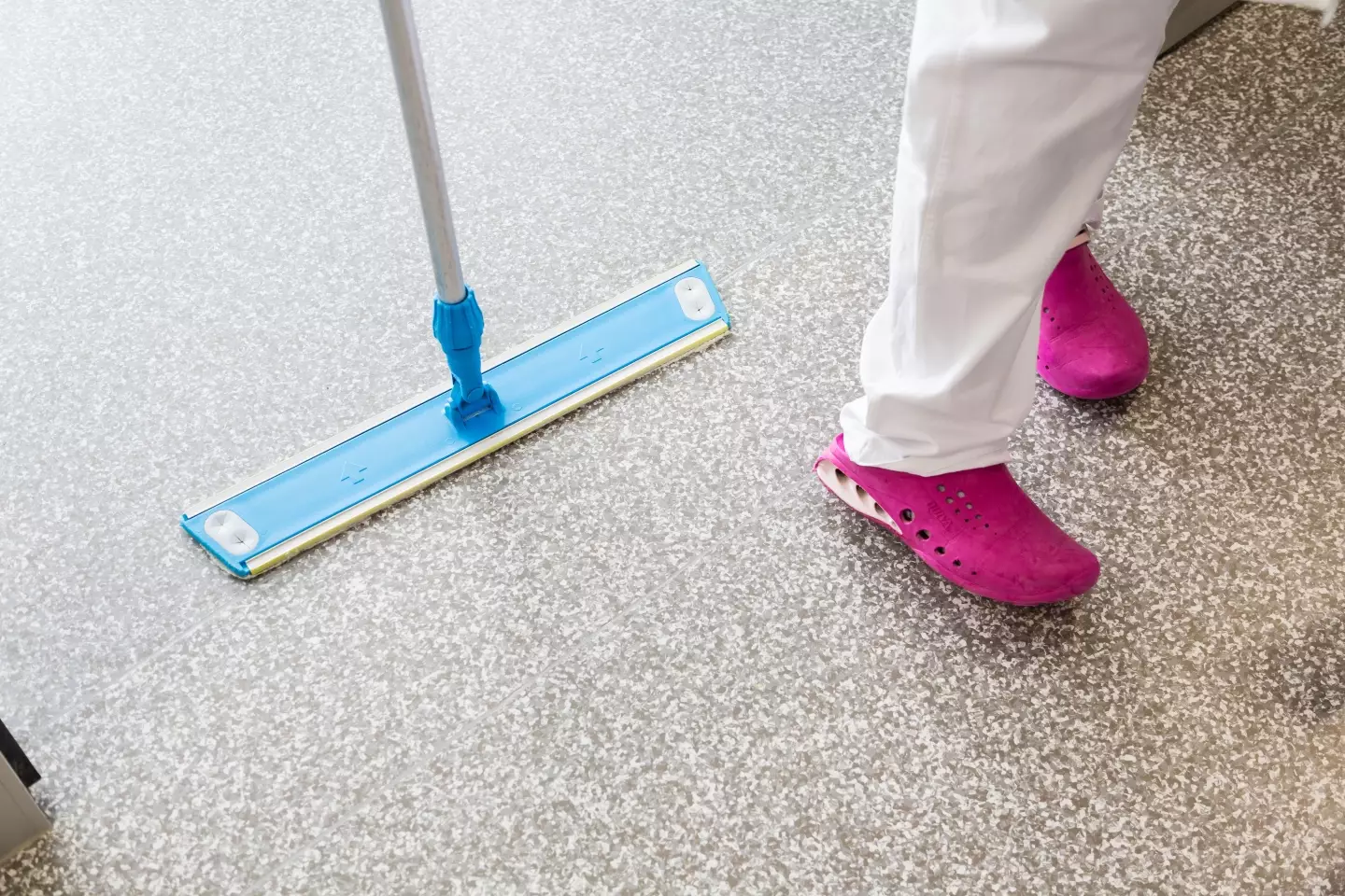 Cleaner mopping a hospital ward floor.
