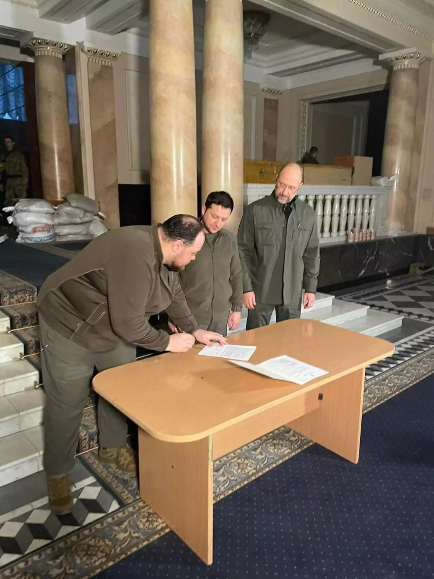 President Zelenskyy signs the document.