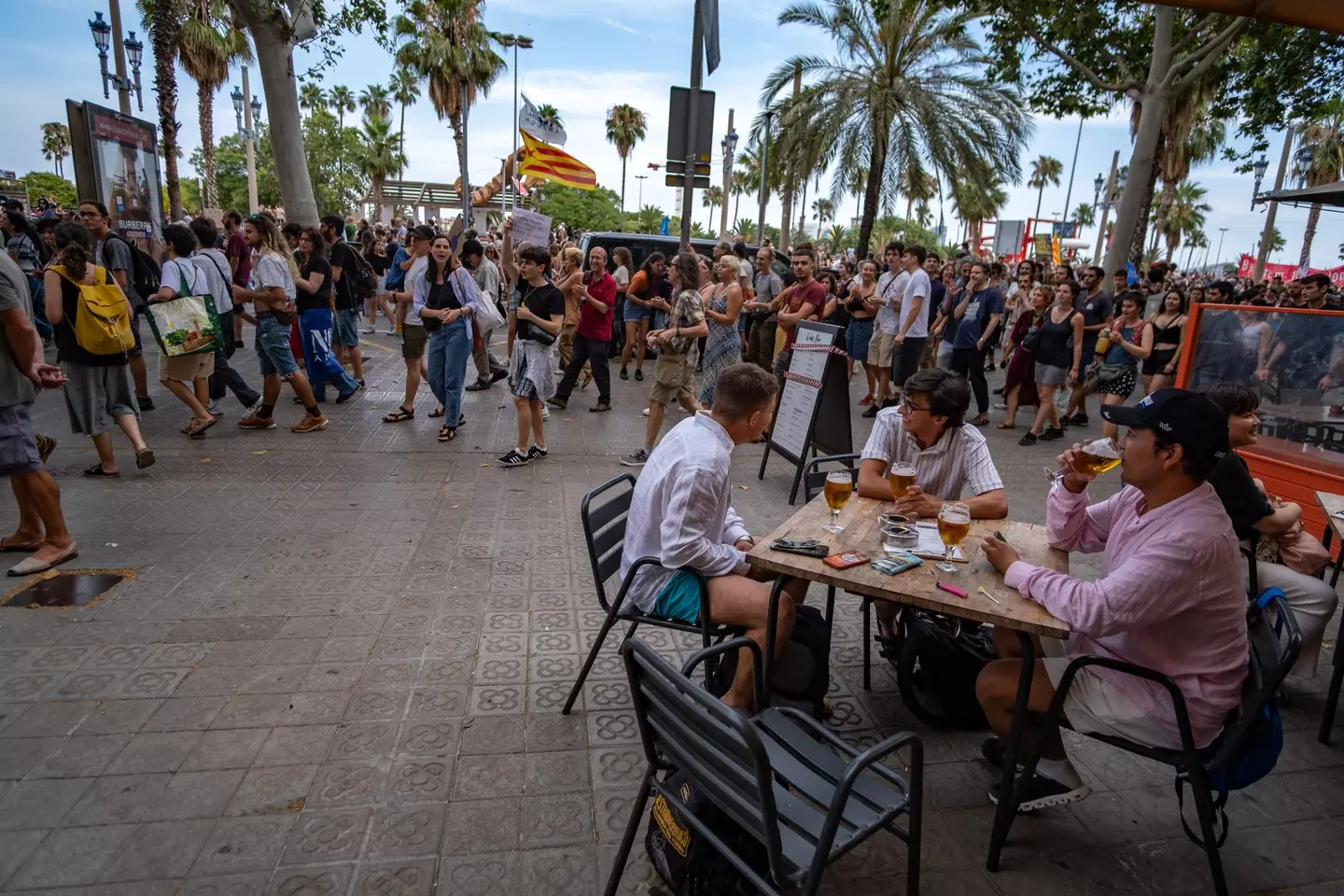 La multitud pasaba mientras los turistas disfrutaban de una bebida (Paco Freire/SOPA Images/LightRocket via Getty Images)
