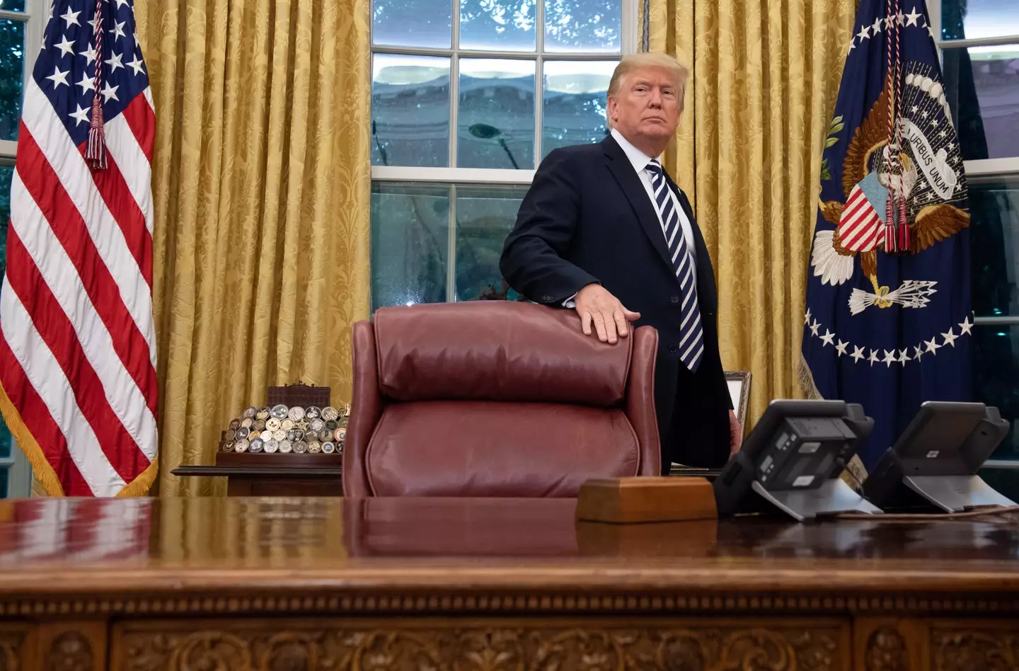 Trump behind the Oval Office desk, with the call button visible (SAUL LOEB/AFP via Getty Images)