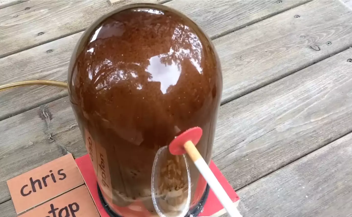 The bell jar was blackened by tar by the end of the experiment (YouTube/@chrisnotap)