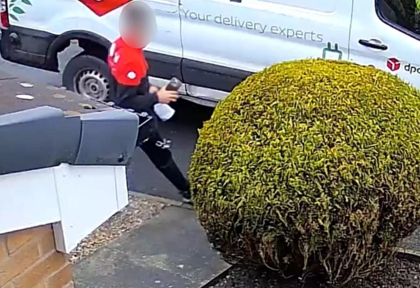 But when he walks back to the van it looks like he's still holding the parcel (Kennedy News and Media)