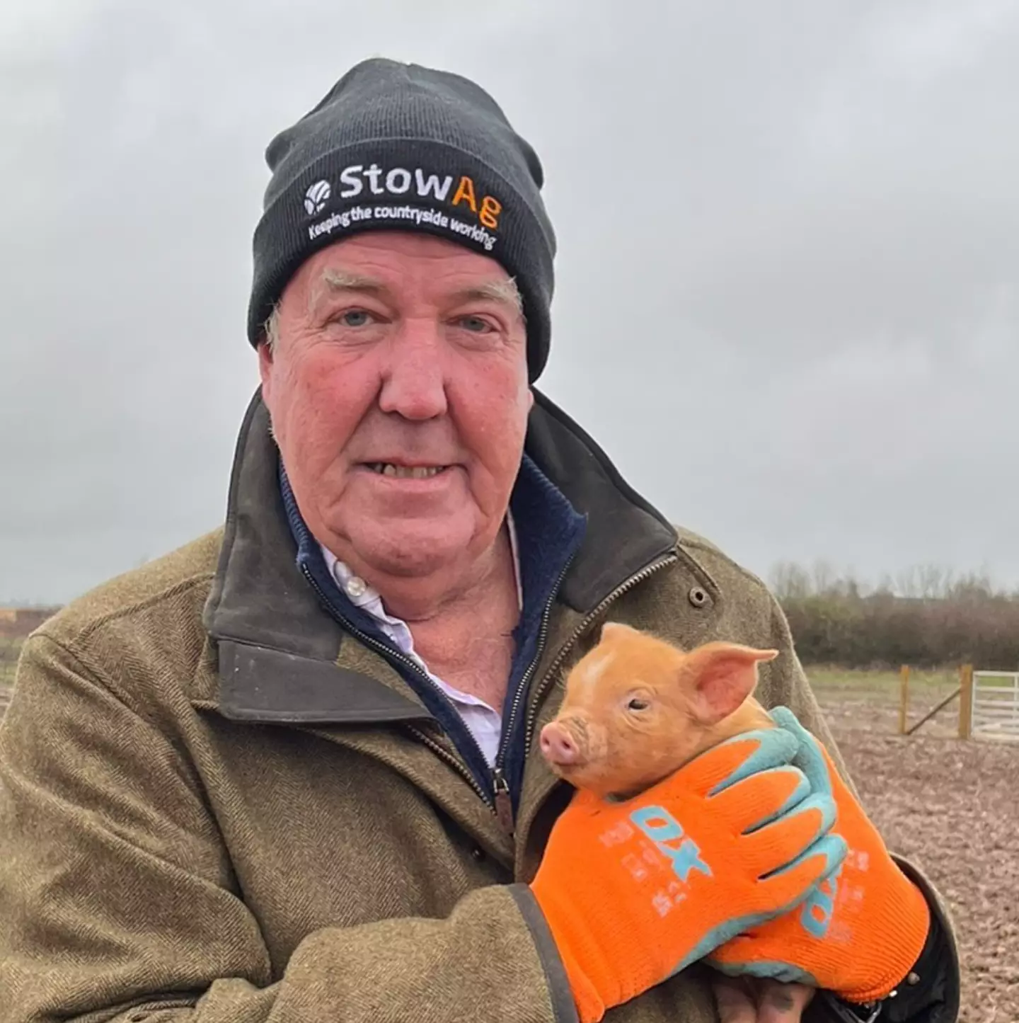 Jeremy Clarkson with a ginger piglet on his farm.