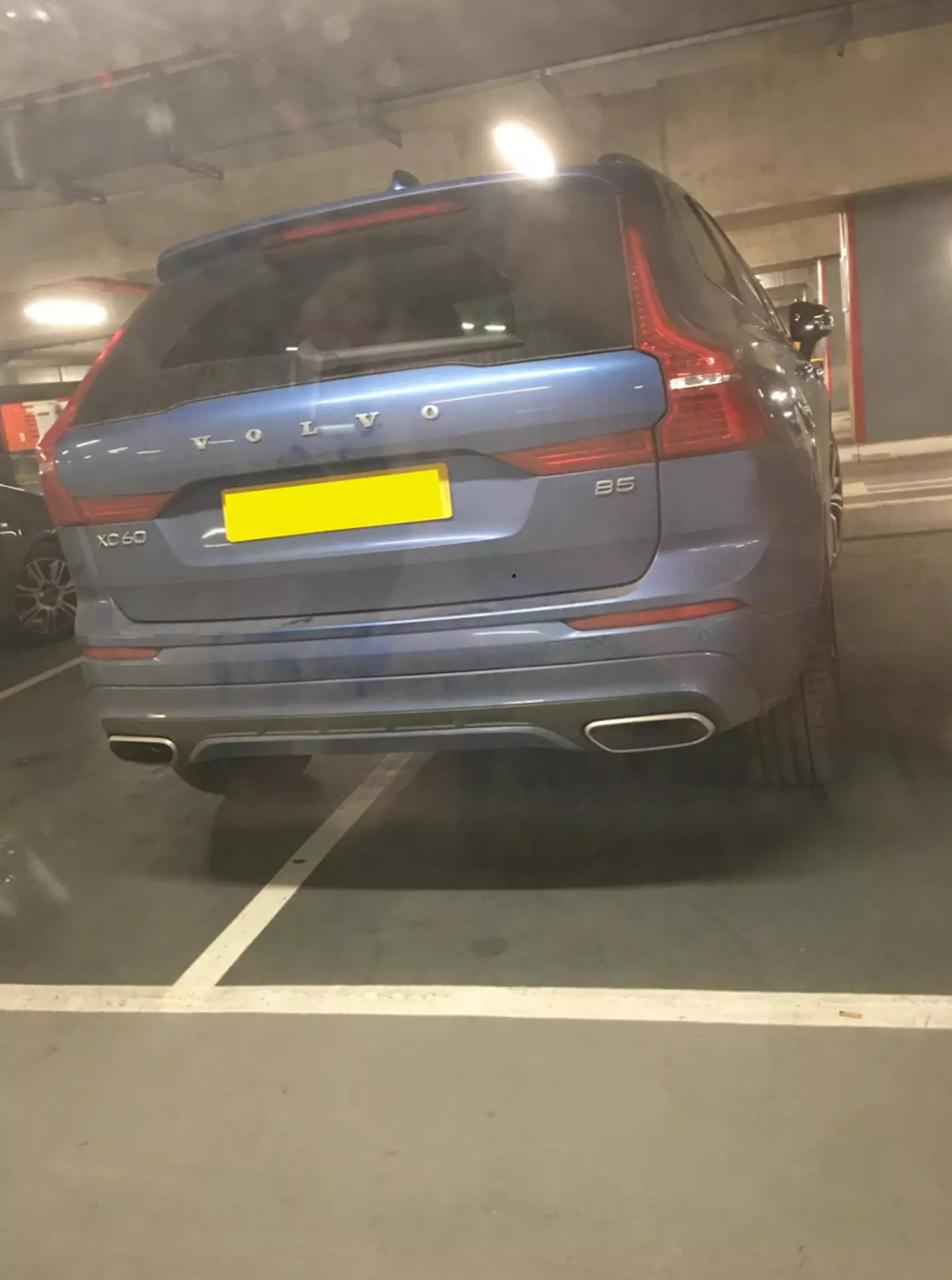 The car was parked in-between two spaces.