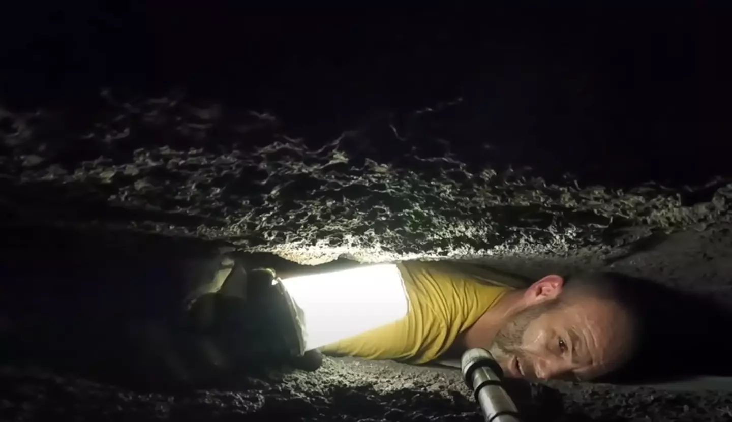 The man was stuck in between rocks in what looks like a claustrophobic nightmare. (Youtube/Caveman Hikes)