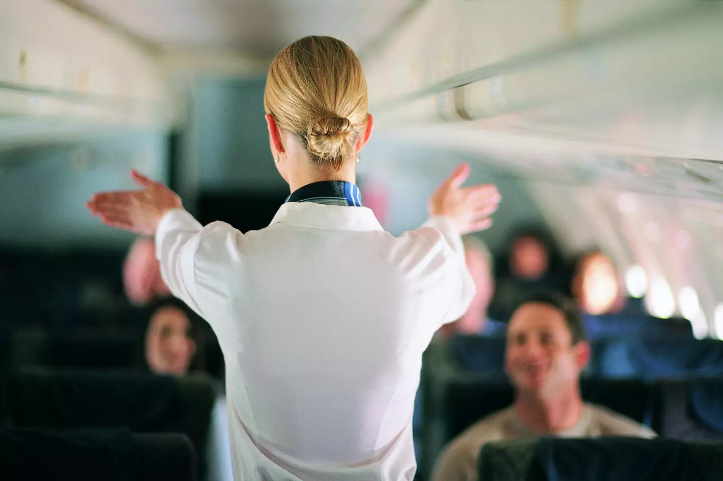 Why do flight attendants sit on their hands?