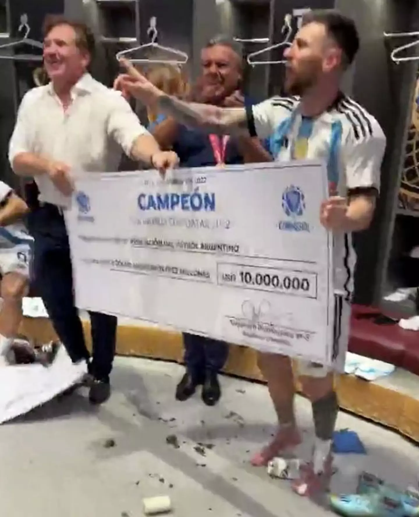 Messi holding the huge cheque.