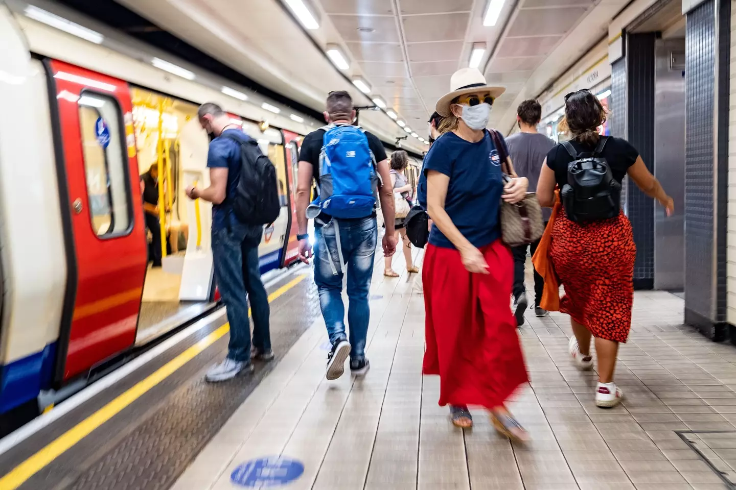 Commuters on a London Underground station platform wearing Covid 19 face masks.