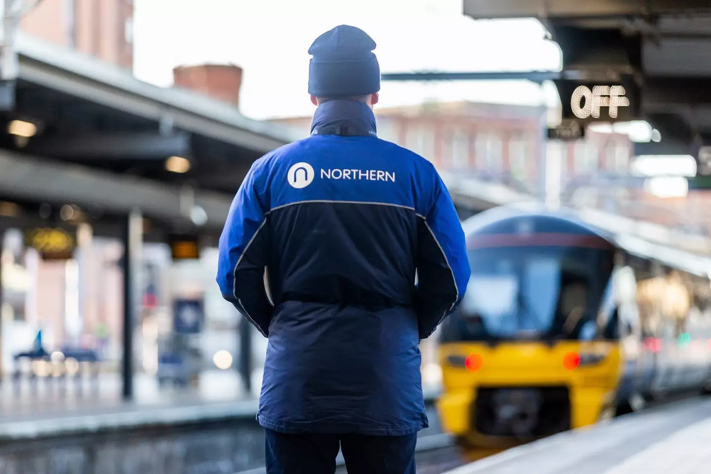 Northern staff watching as a train arrives at a platform.