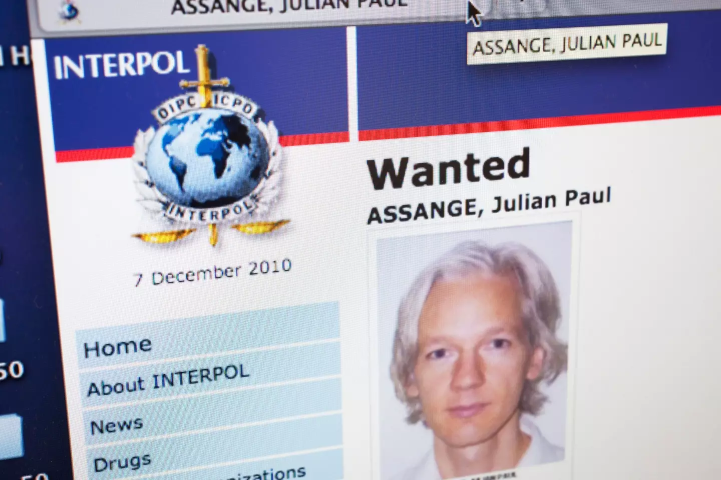 Website for Interpol showed Julian Assange's status as Wanted.