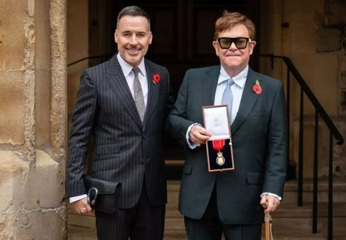Sir Elton John with his husband David Furnish (left) after being made a member of the Order of the Companions of Honour.(