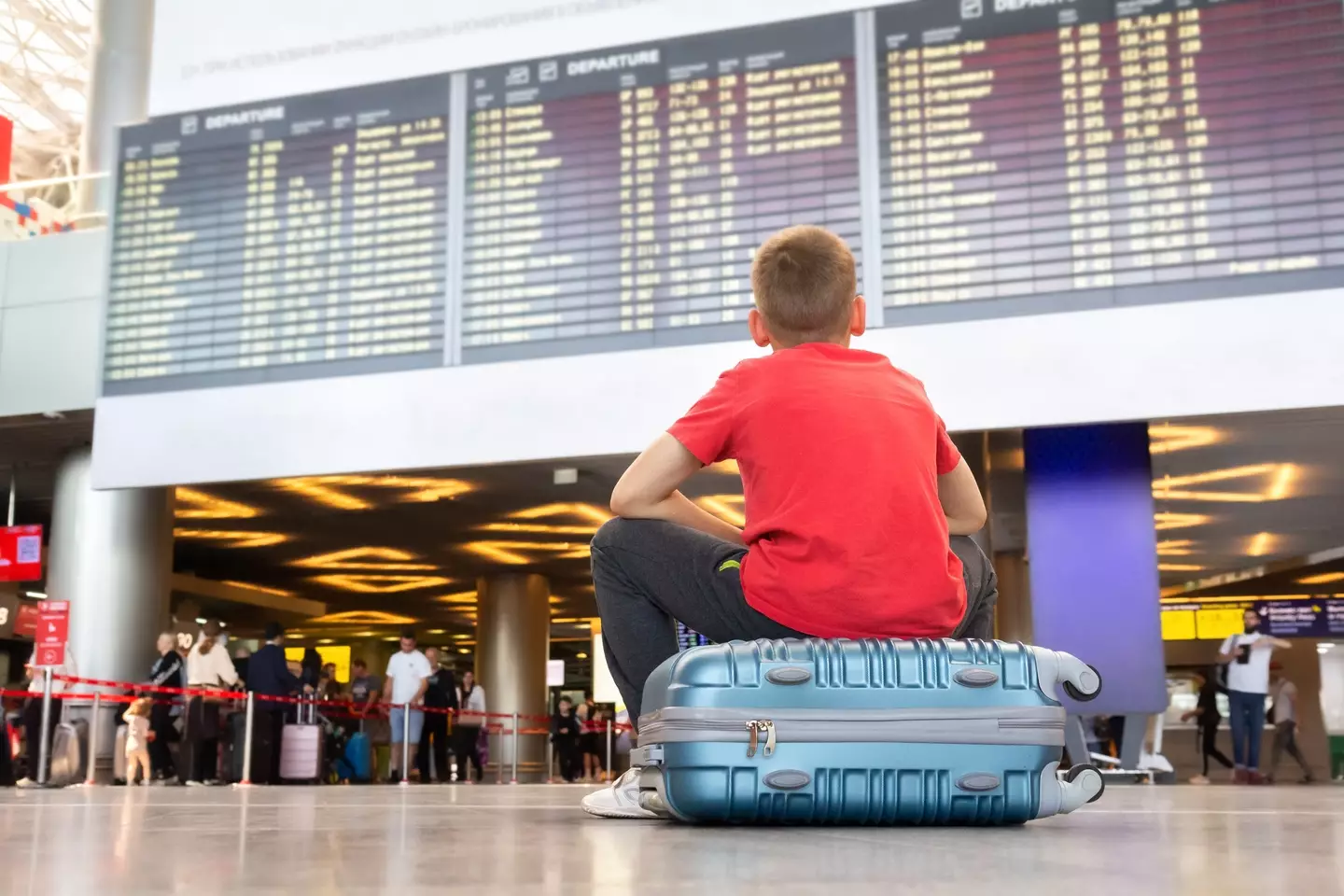 A boy looks at a flight information board after his flight is canned.