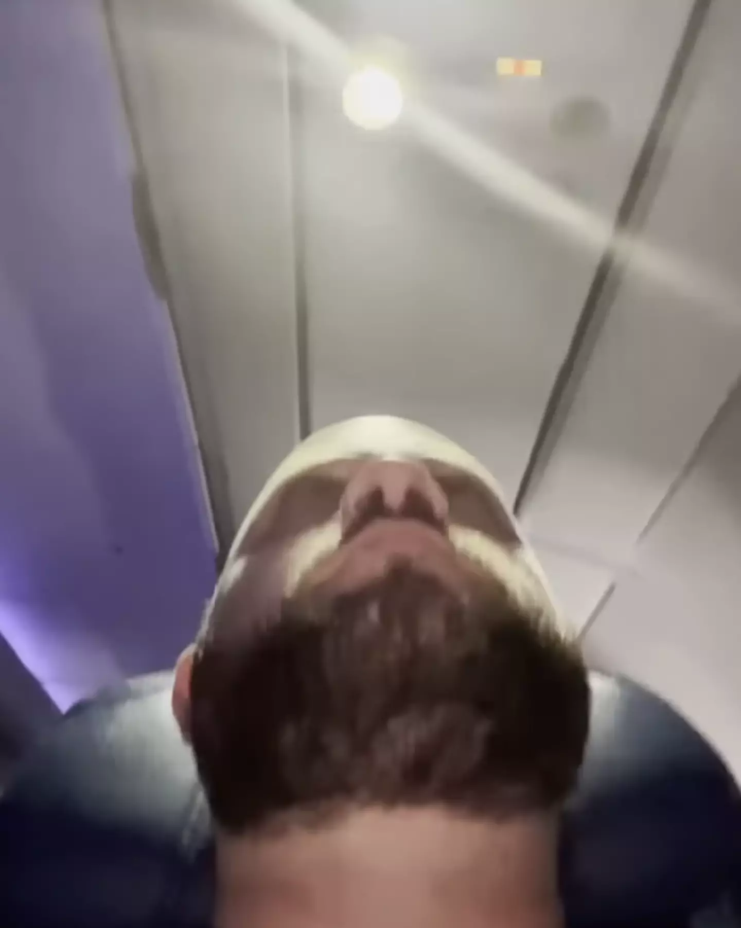 He couldn't even nap on the flight as a neighbour who had thought to bring some books was using the reading light. (YouTube/@movieblues420)