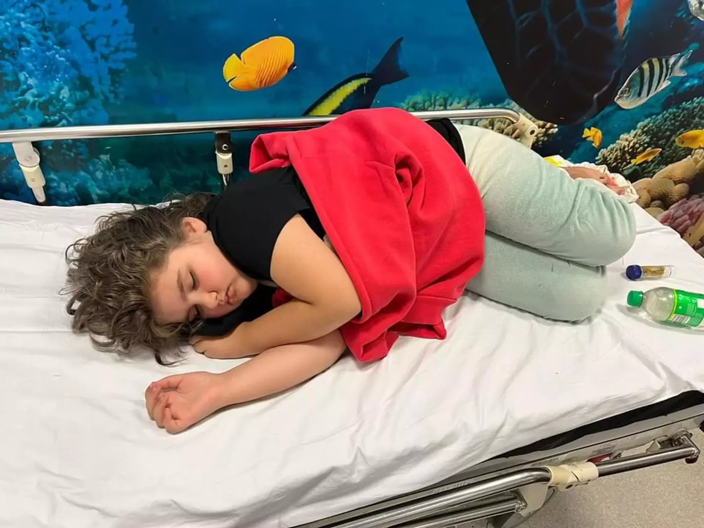 Eight-year-old Amelia lying on a hospital bed (Collect/PA Real Life)