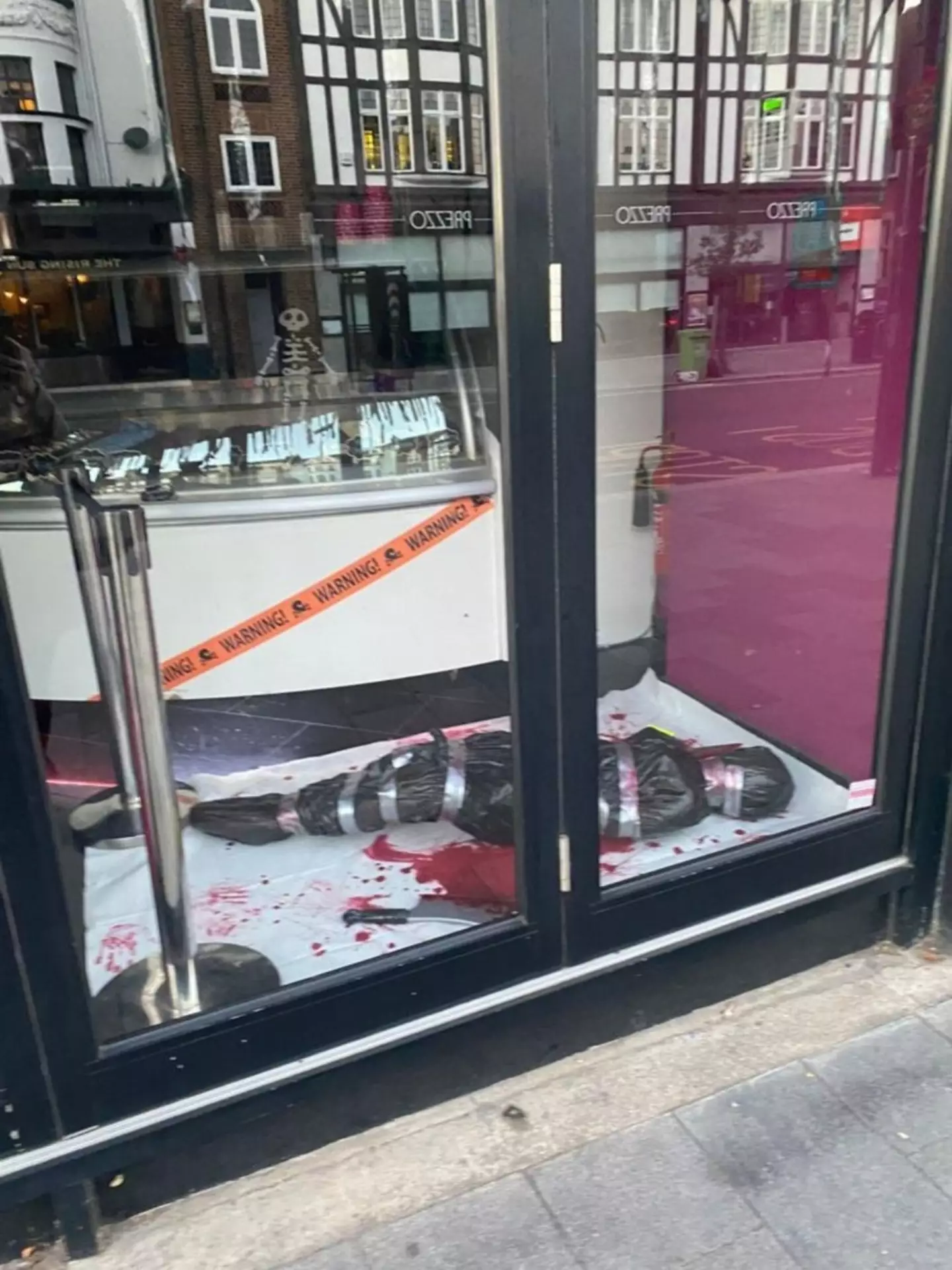 The display features crime scene tape and a fake dead body wrapped up in a bin bag and tape.