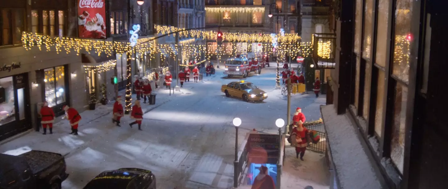 The World Needs More Santas advert starts off with a bunch of Santas roaming the streets.