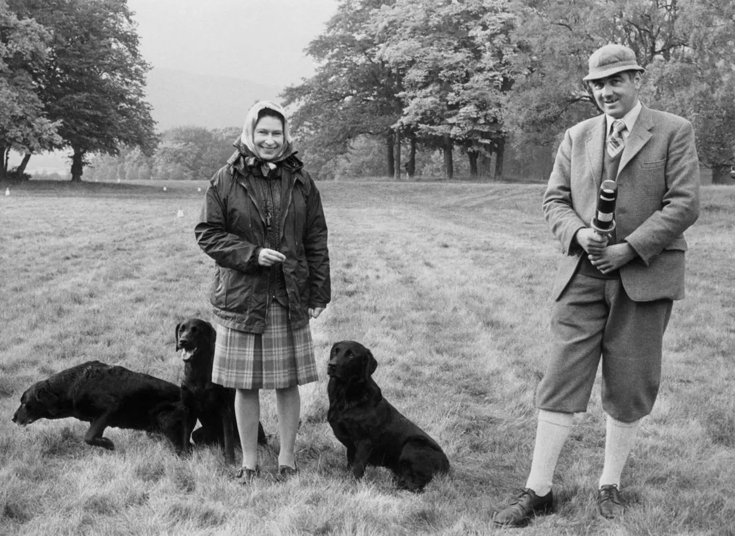 Queen Elizabeth II at Balmoral Castle in Scotland, accompanied by her dog trainer and Game Keeper, Bill Meldrum in 1977.