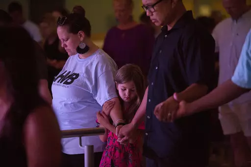 A little girl holding her mother after a mass shooting earlier this year.