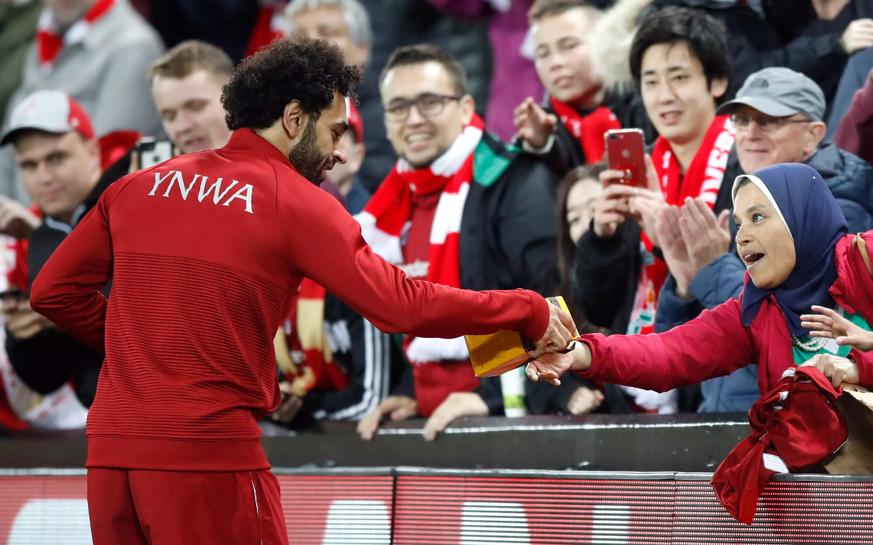 Salah takes the chocolates after handing over his shirt. Image: PA Images