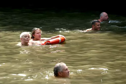 People swimming at the mixed bathing pond on Hampstead Heath, London.
