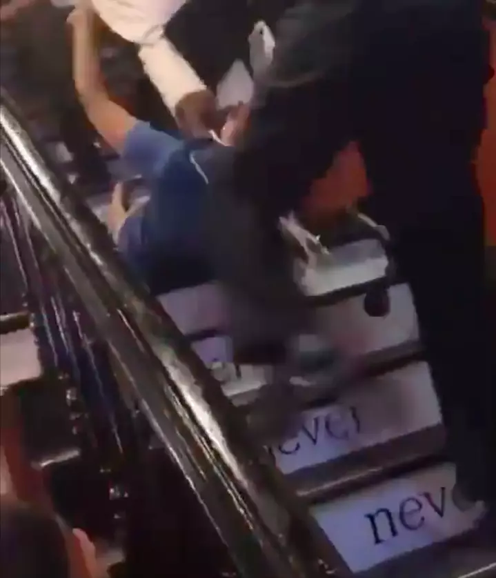 A young woman was dragged down the stairs by security (