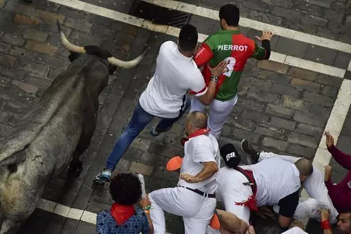 Revellers run next to fighting bulls during the running of the bulls at one of the other festivals.
